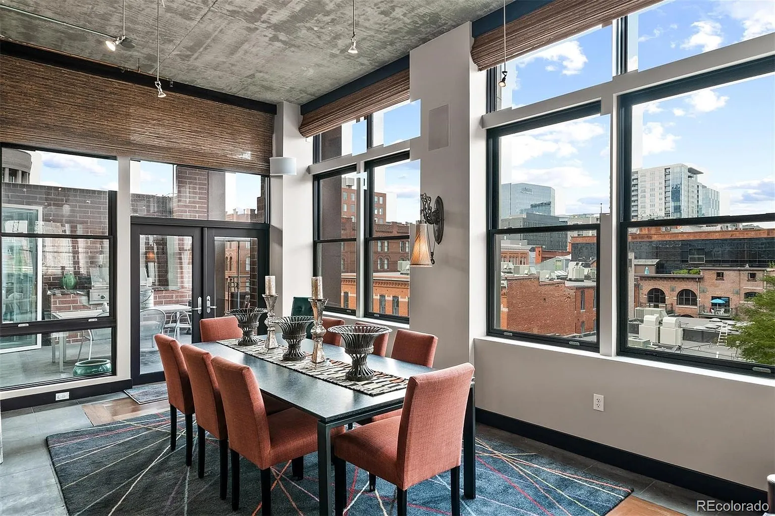 Dining area beside floor-to-ceiling windows with skyline views