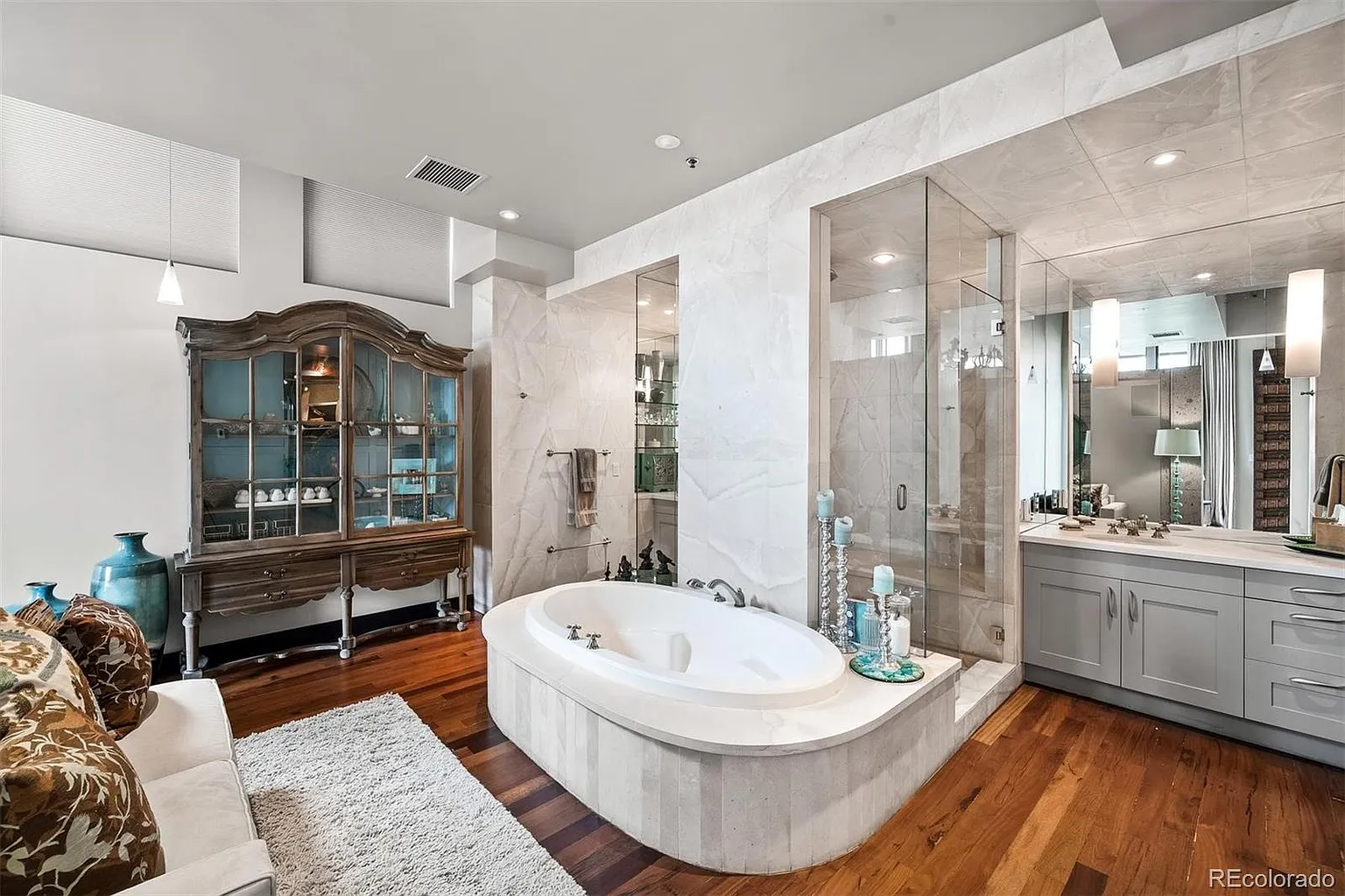 Spa-style primary bath with soaking tub and glass shower